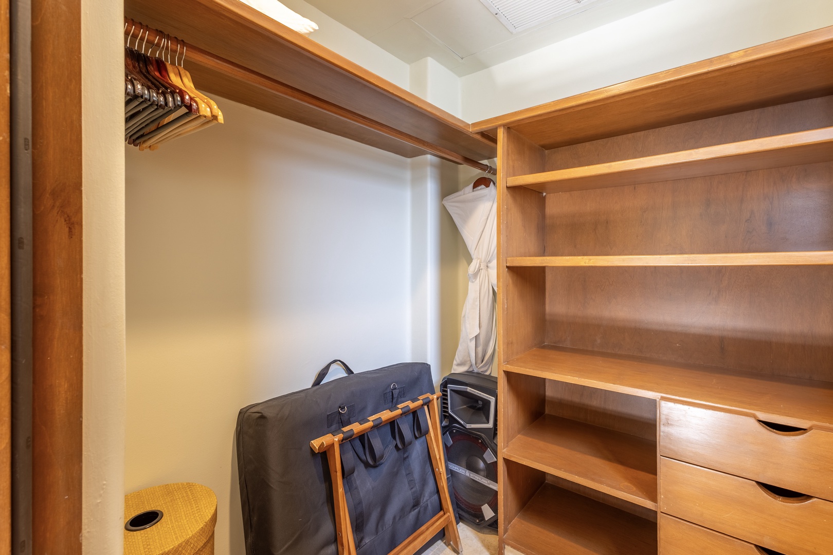 Your spacious walk-in closet features warm wood shelving and hangers, offering plenty of organized storage for your vacation wardrobe.