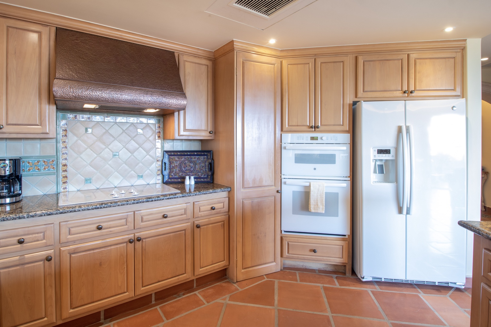 Your fully-equipped kitchen features warm wood cabinets, granite countertops, and modern appliances, ready for you to prepare meals just the way you like them.