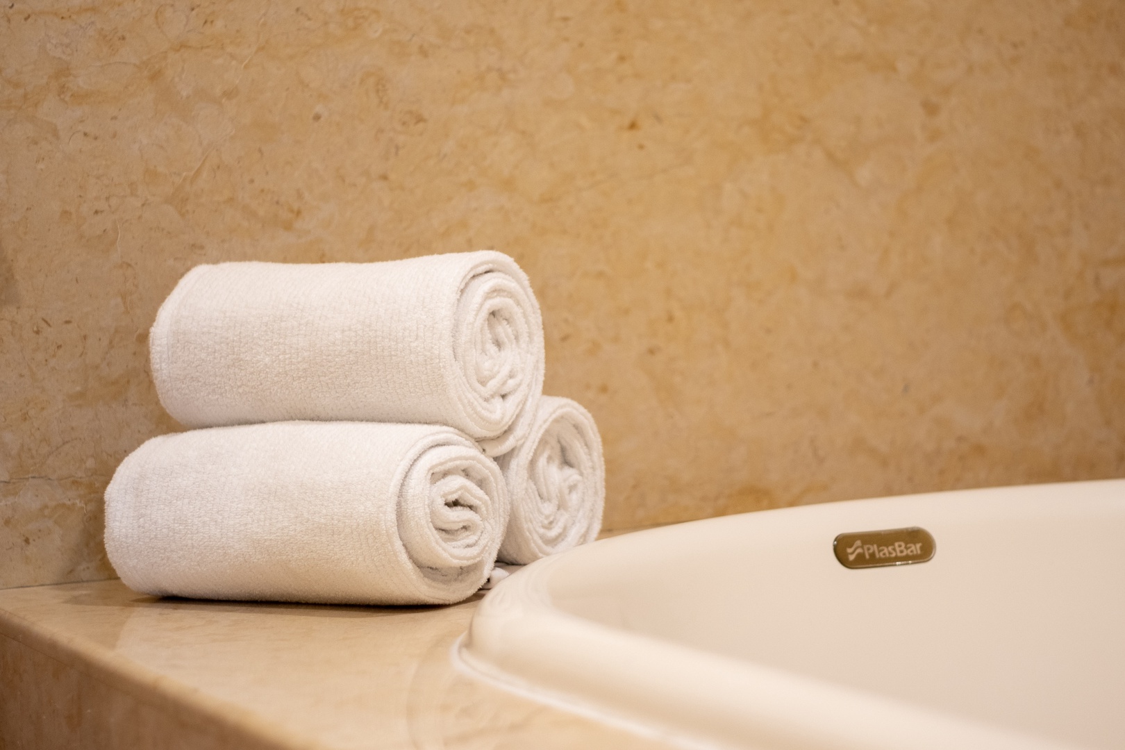 Fresh towels are rolled and ready for you beside a welcoming bathtub, setting the stage for a soothing, rejuvenating soak after your day of adventure.