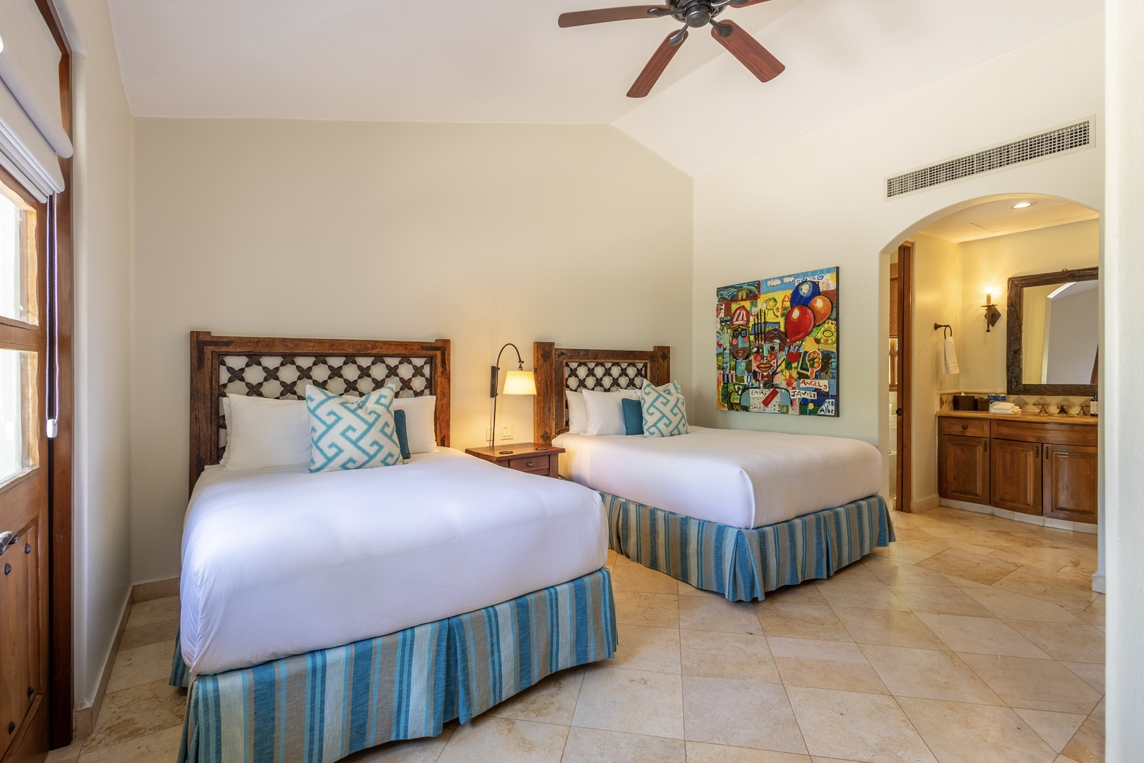 Your spacious twin bedroom offers crisp linens, vibrant art, and a peaceful ceiling fan for ultimate comfort.