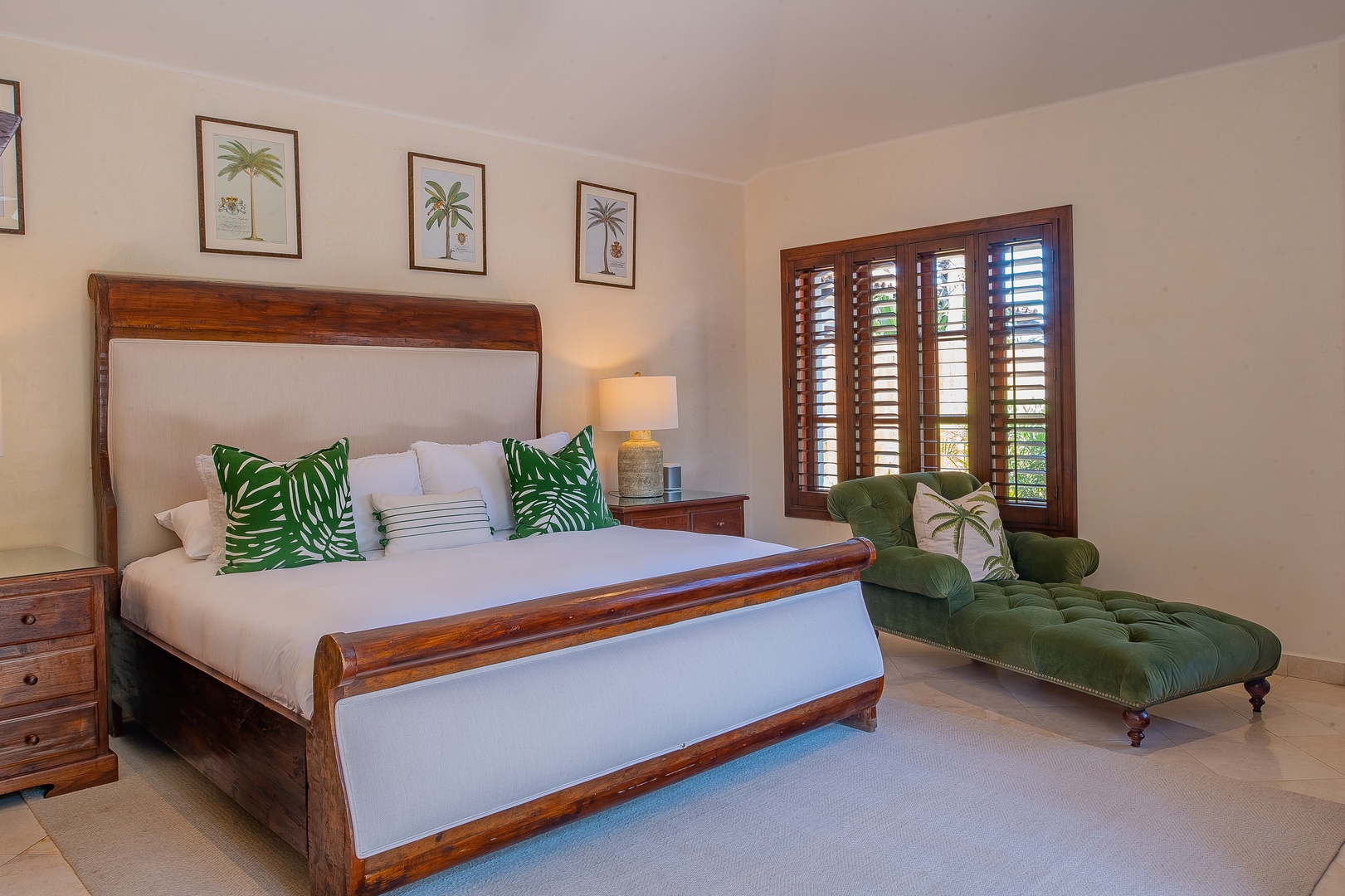 Sink into crisp white linens with tropical palm accents, while sunlight filters through plantation shutters onto your elegant green velvet chaise.