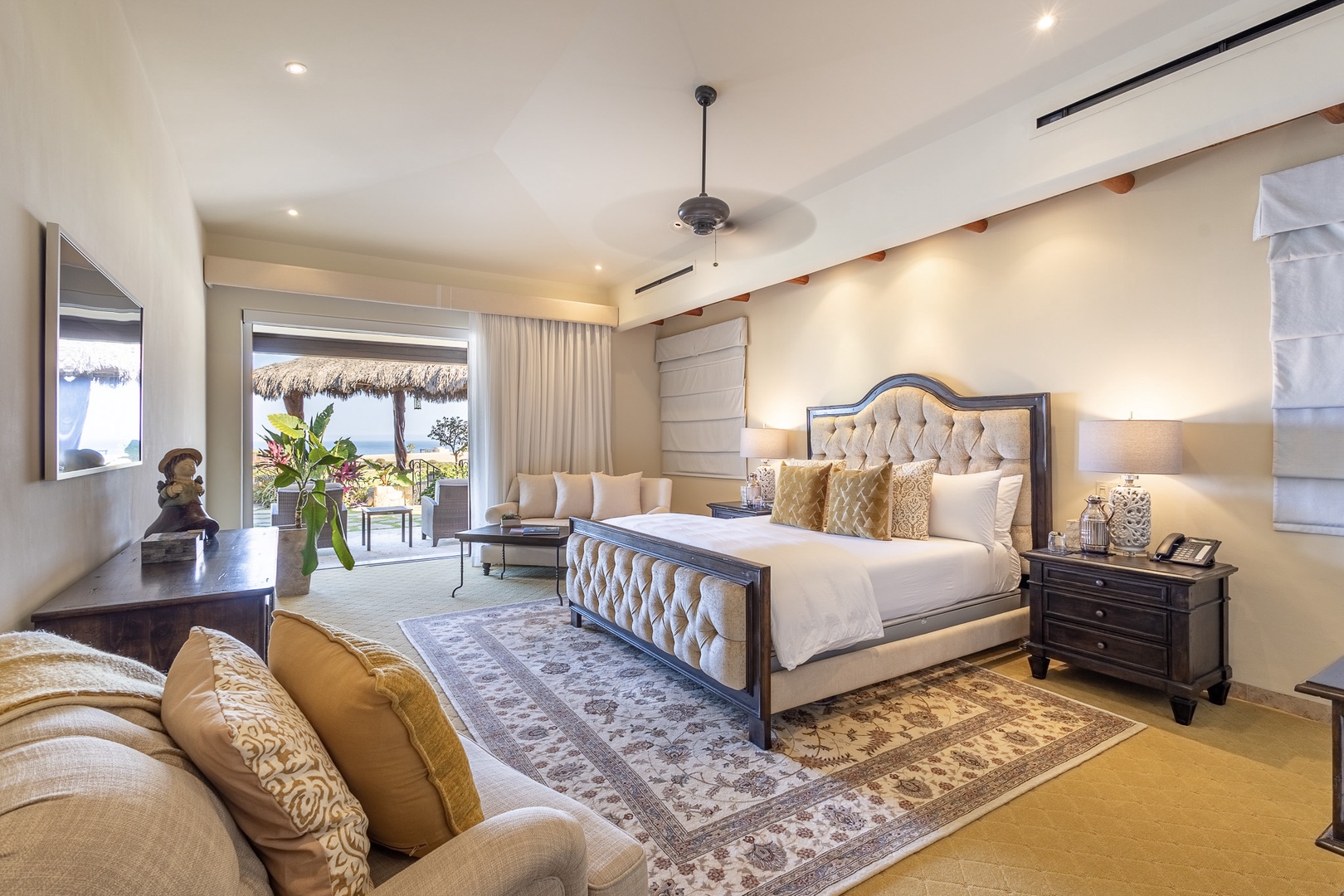 Sink into the plush king bed with its tufted headboard, unwind on the cozy seating, and let the ocean breeze drift in through your private terrace doors—your serene coastal retreat awaits.