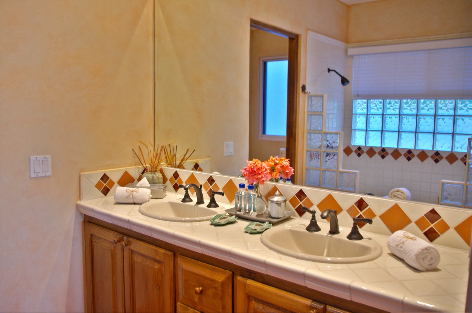 Freshen up at your spacious double vanity, beautifully accented with hand-painted tiles and natural light—perfect for sharing the morning routine comfortably.
