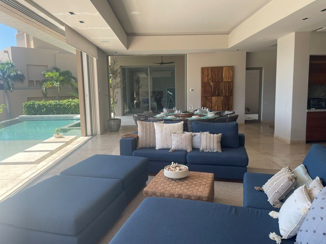 Sink into plush seating and enjoy seamless indoor-outdoor living with your private pool just steps away through floor-to-ceiling glass doors.