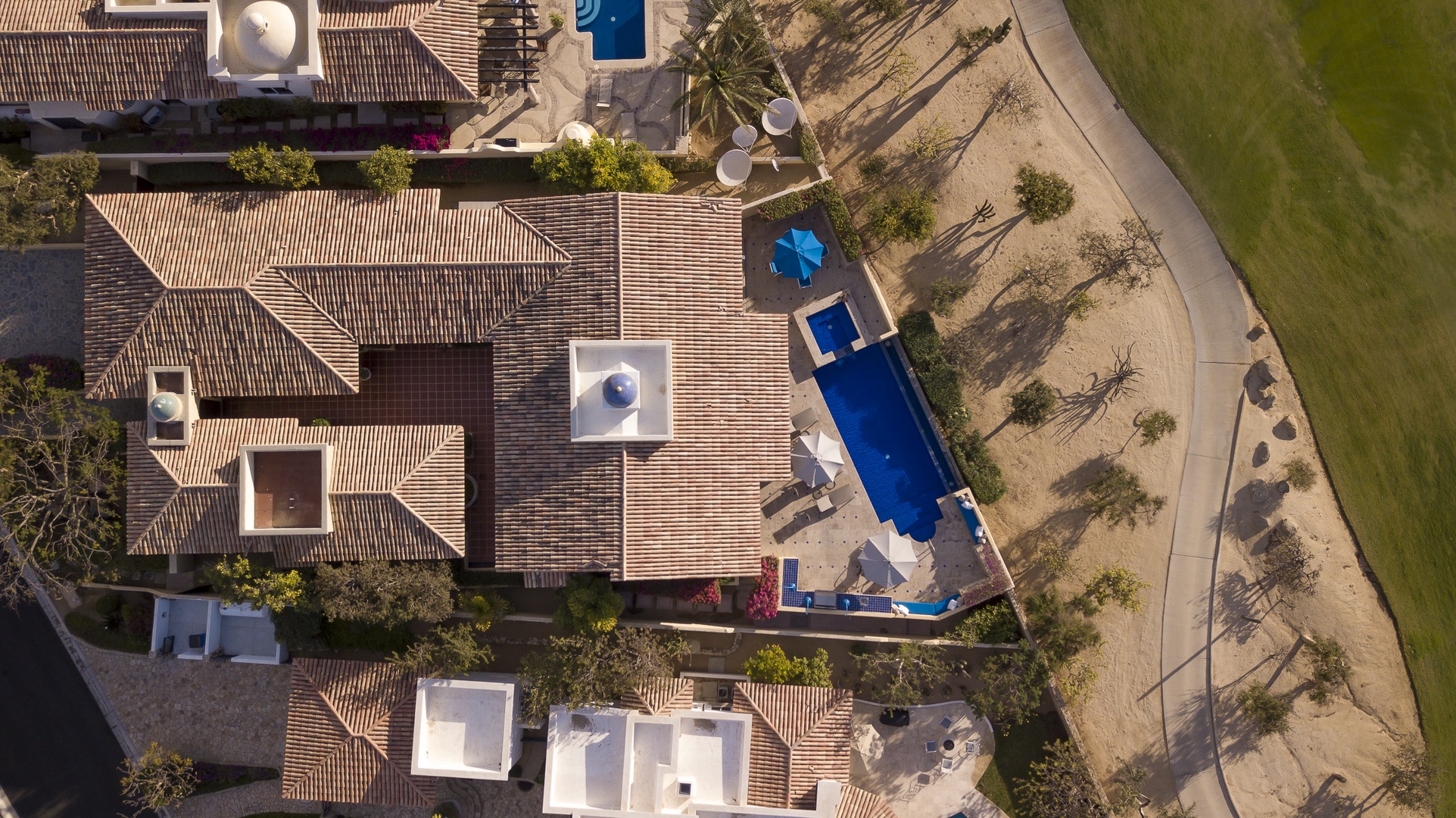 Aerial view of the vacation property showcasing the stunning swimming pool and spacious outdoor areas surrounded by natural landscaping.