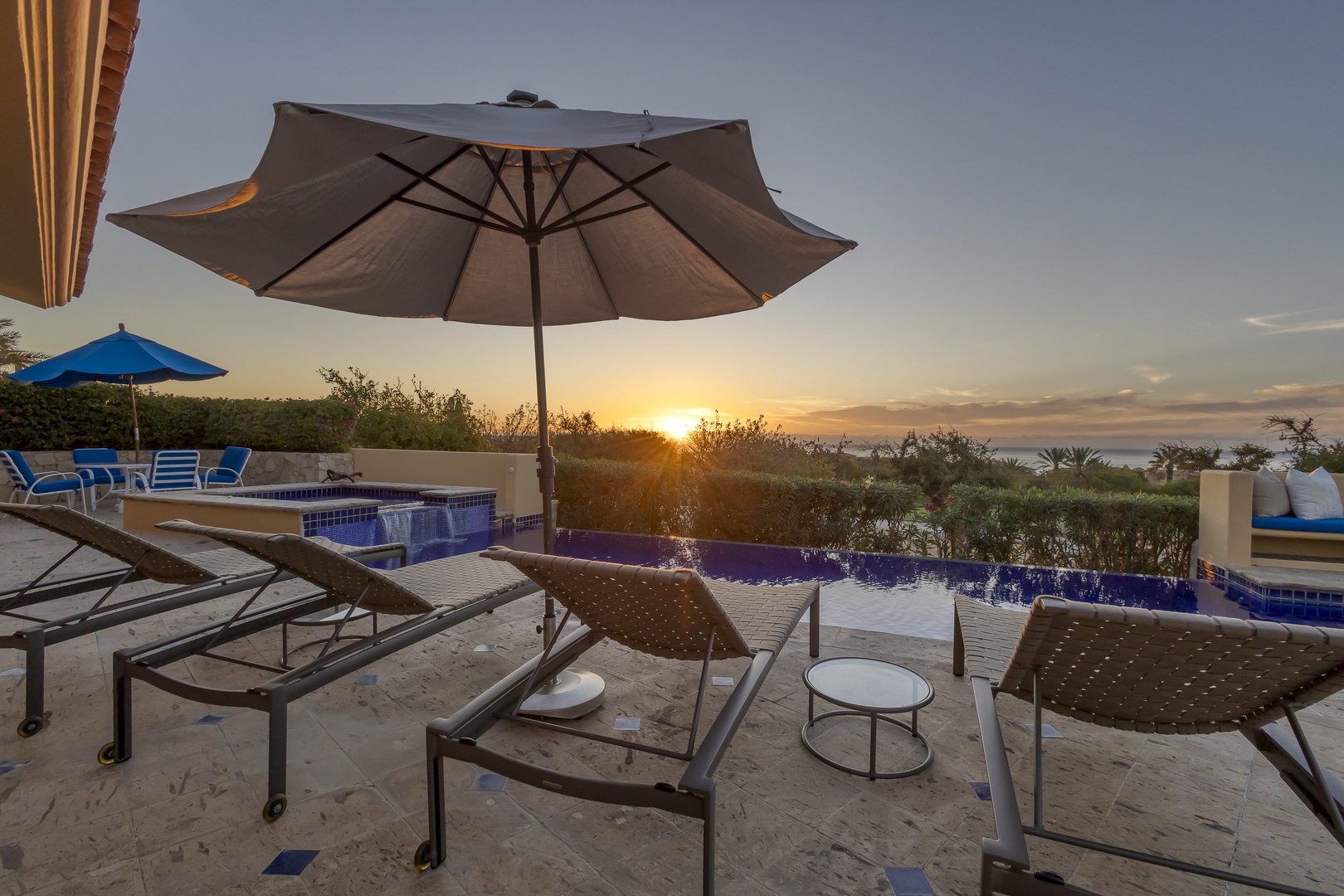 Stunning sunset views over the ocean from this private pool terrace, complete with comfortable loungers and umbrella for the perfect evening unwind.