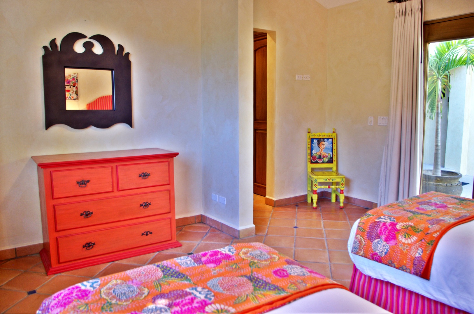 Two plush beds draped in vibrant patchwork quilts welcome you to your colorful retreat, with charming folk-art furnishings adding authentic local character.