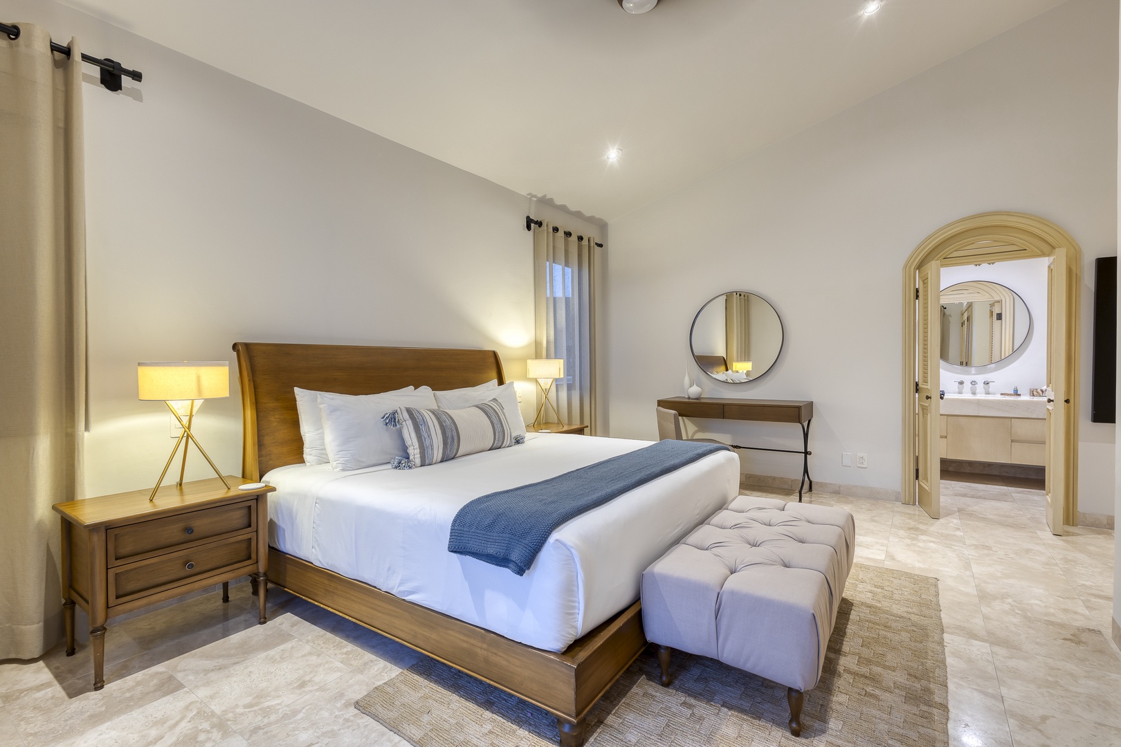 Step into your tranquil bedroom retreat, where crisp white linens meet warm wood tones. Soft lighting, a tufted bench, and an elegant archway to your private ensuite create the perfect sanctuary for rest.