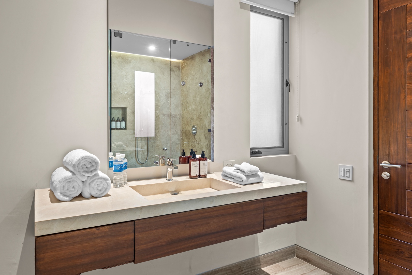Slip into relaxation in your spa-inspired bathroom with a modern glass shower, plush towels awaiting, and a sleek vanity with luxurious amenities—your private sanctuary.