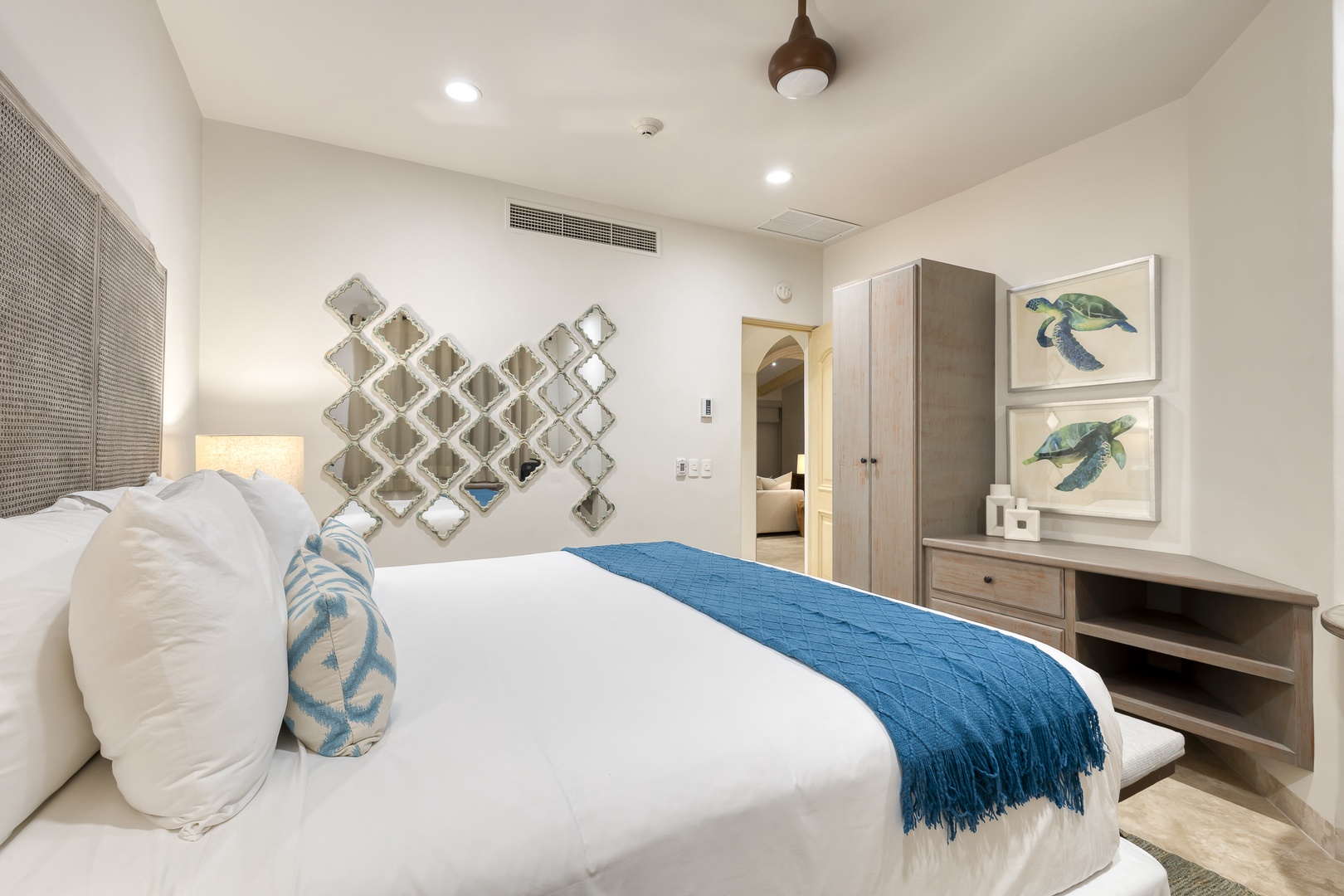 Sink into crisp white linens and coastal charm. Your serene retreat features thoughtful artwork, cool breezes from modern climate control, and all the comforts you need for a restful stay.