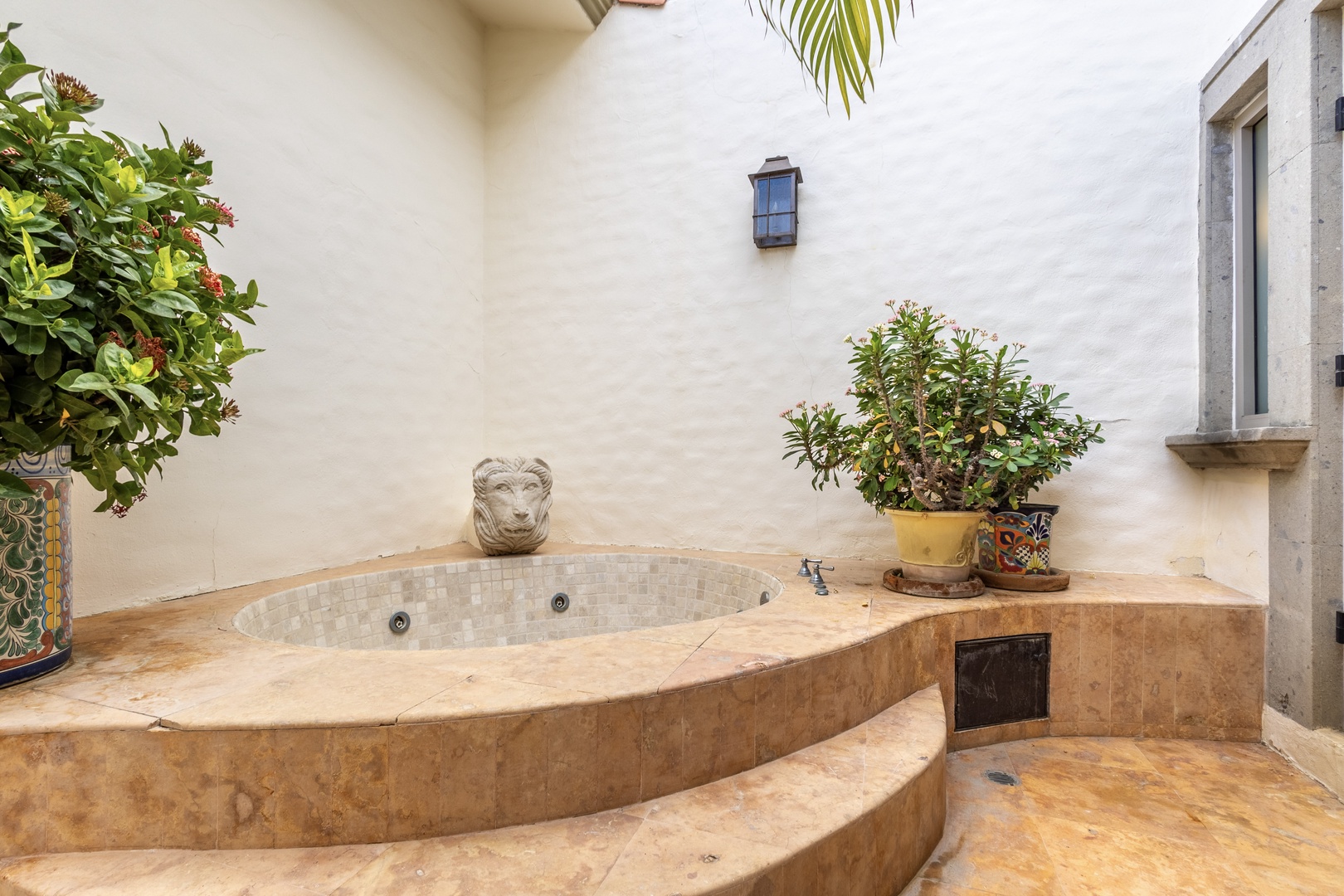 Unwind in your private courtyard hot tub, surrounded by lush greenery and Mediterranean charm. Let the soothing jets melt away stress under the open sky.