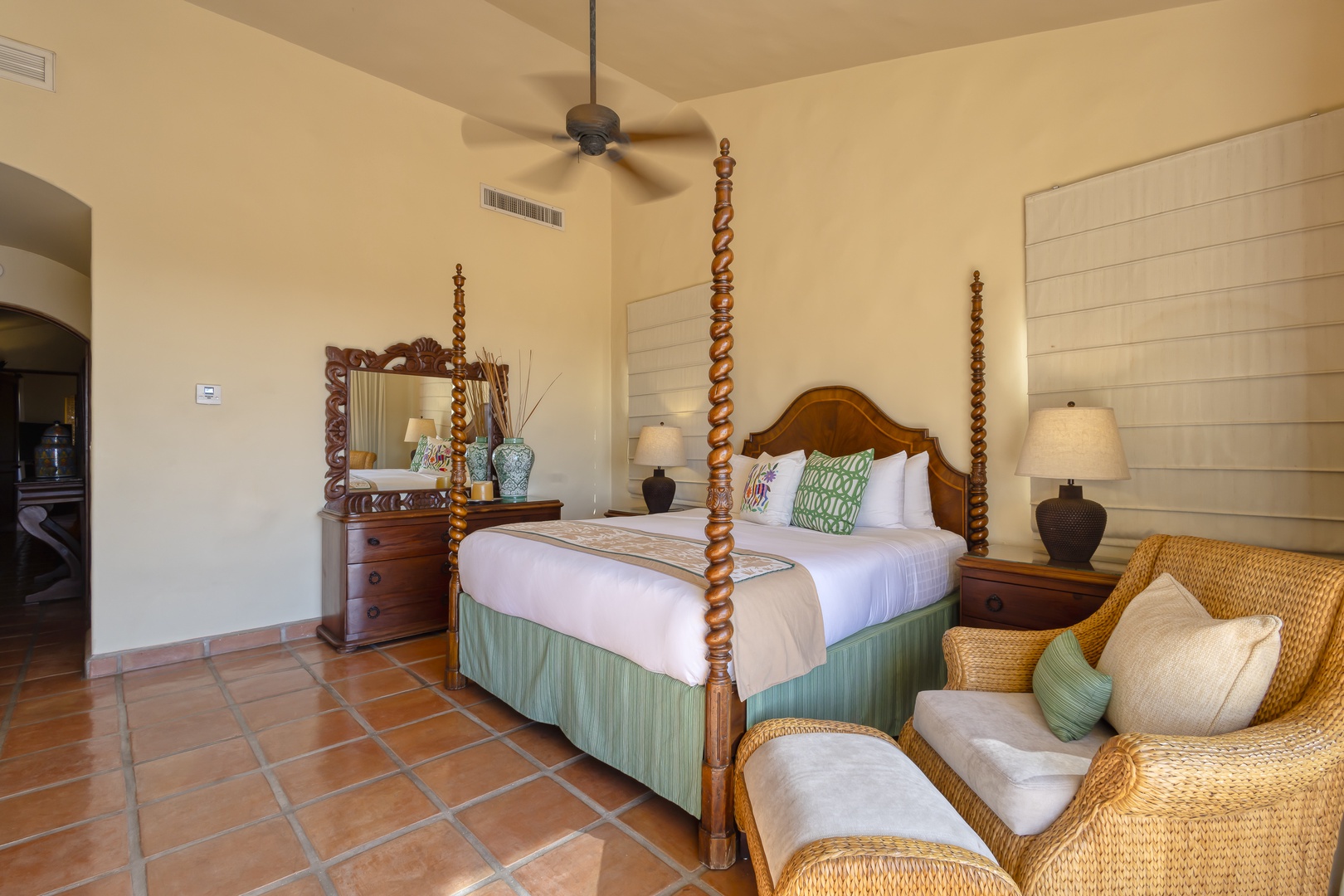 Your elegant bedroom features a handcrafted four-poster bed and cozy wicker seating where you can unwind in tropical comfort.