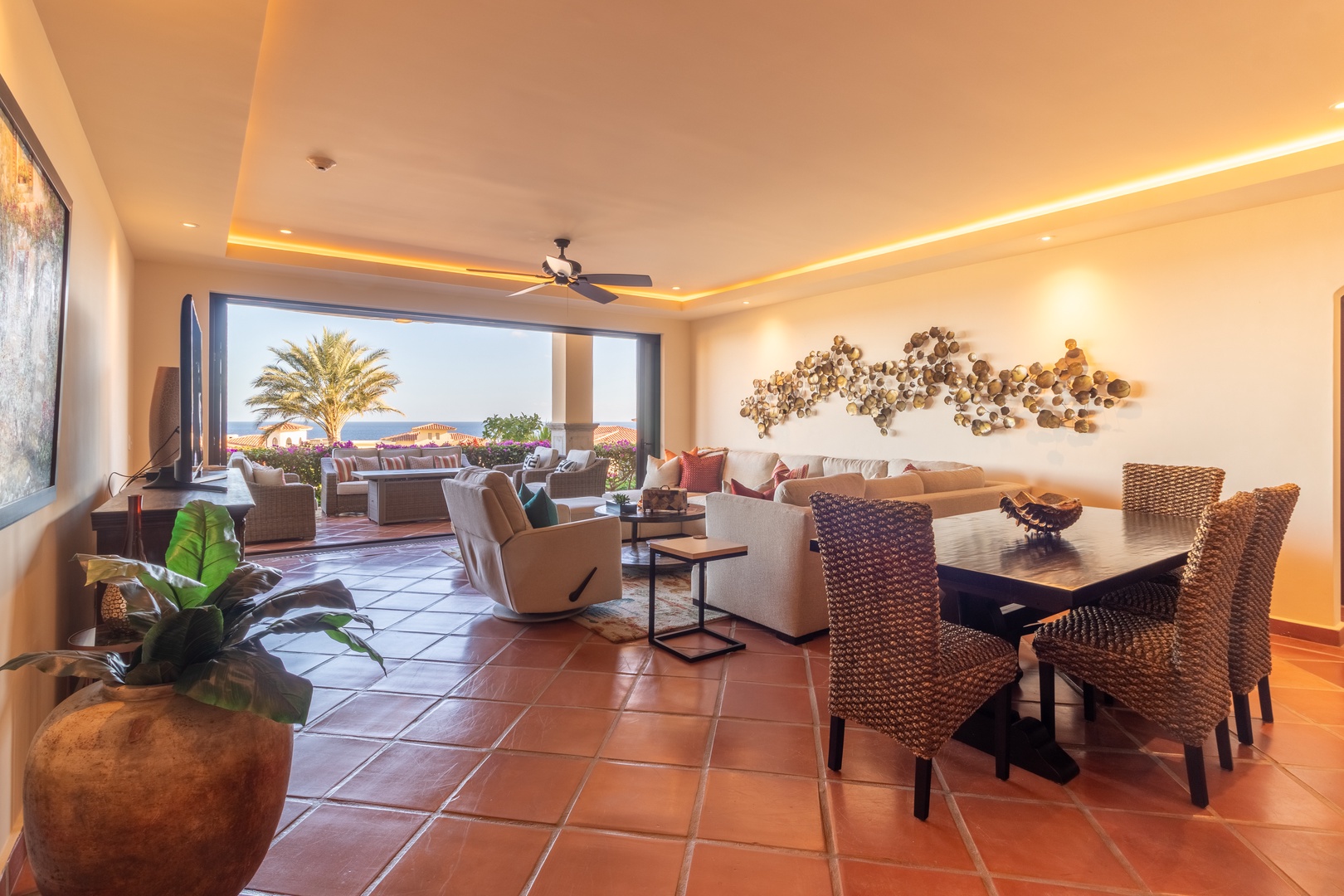 Your open-concept living and dining space invites relaxation with ocean breezes, coastal decor, and stylish woven seating—perfect for memorable evenings with loved ones.
