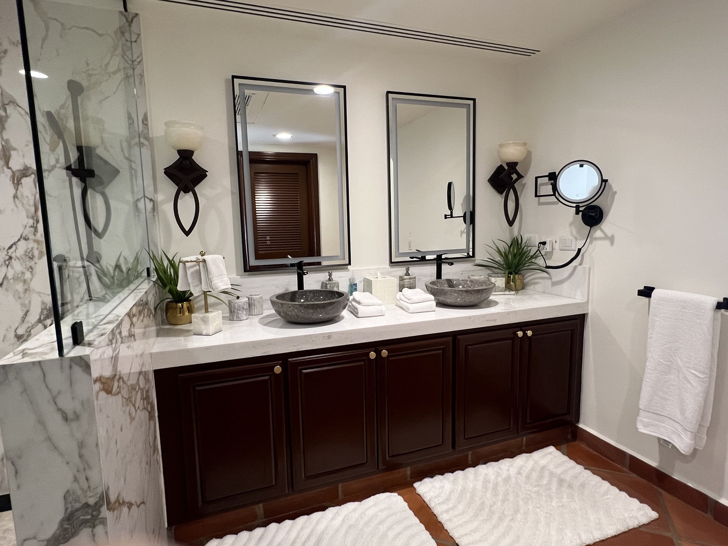 Unwind in your luxurious double-vanity bathroom with elegant stone sinks, heated marble shower, and plush towels—spa-like comfort awaits you.