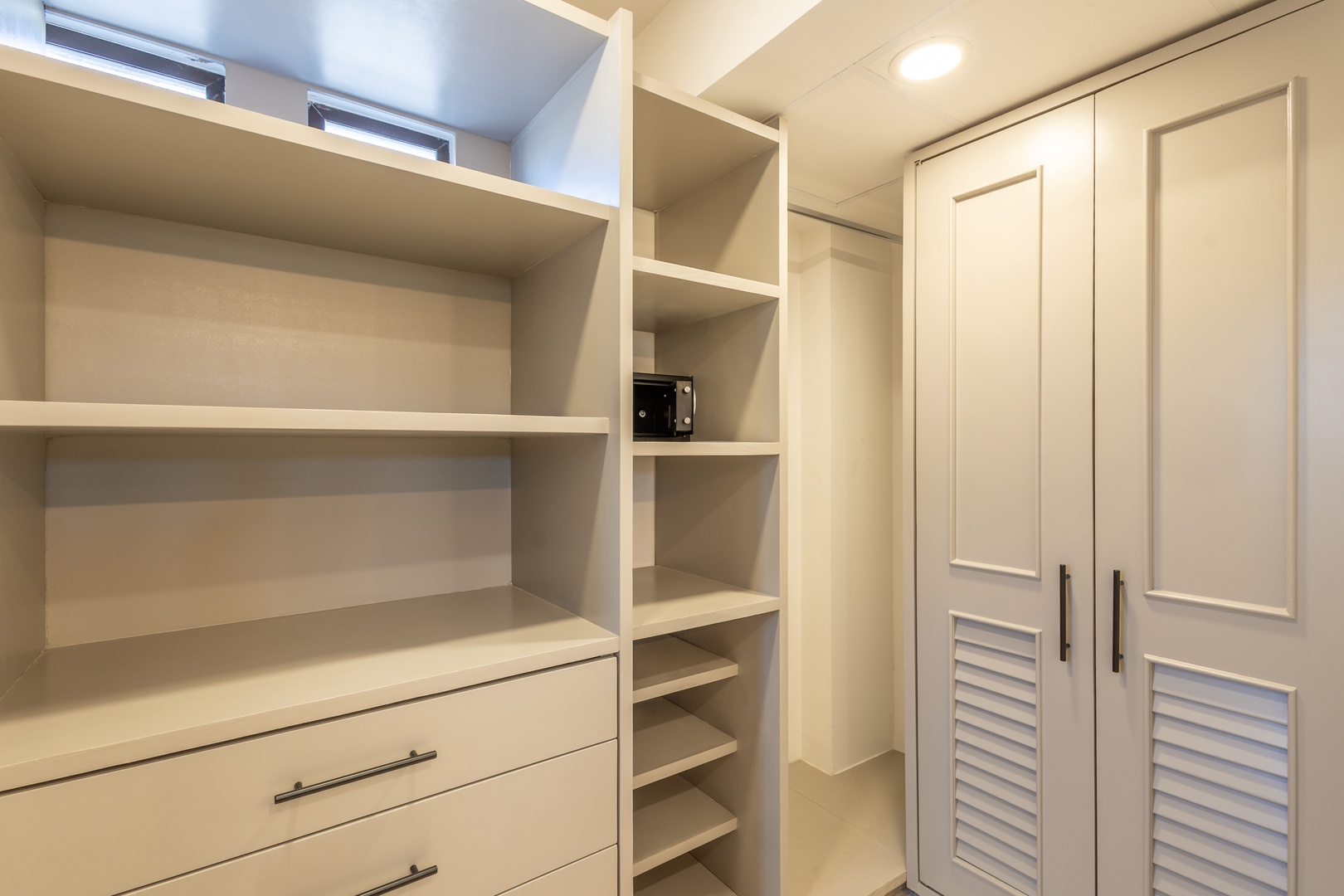 Store your belongings with ease in this spacious walk-in closet featuring shelves, drawers, and hanging space to keep everything organized during your stay.