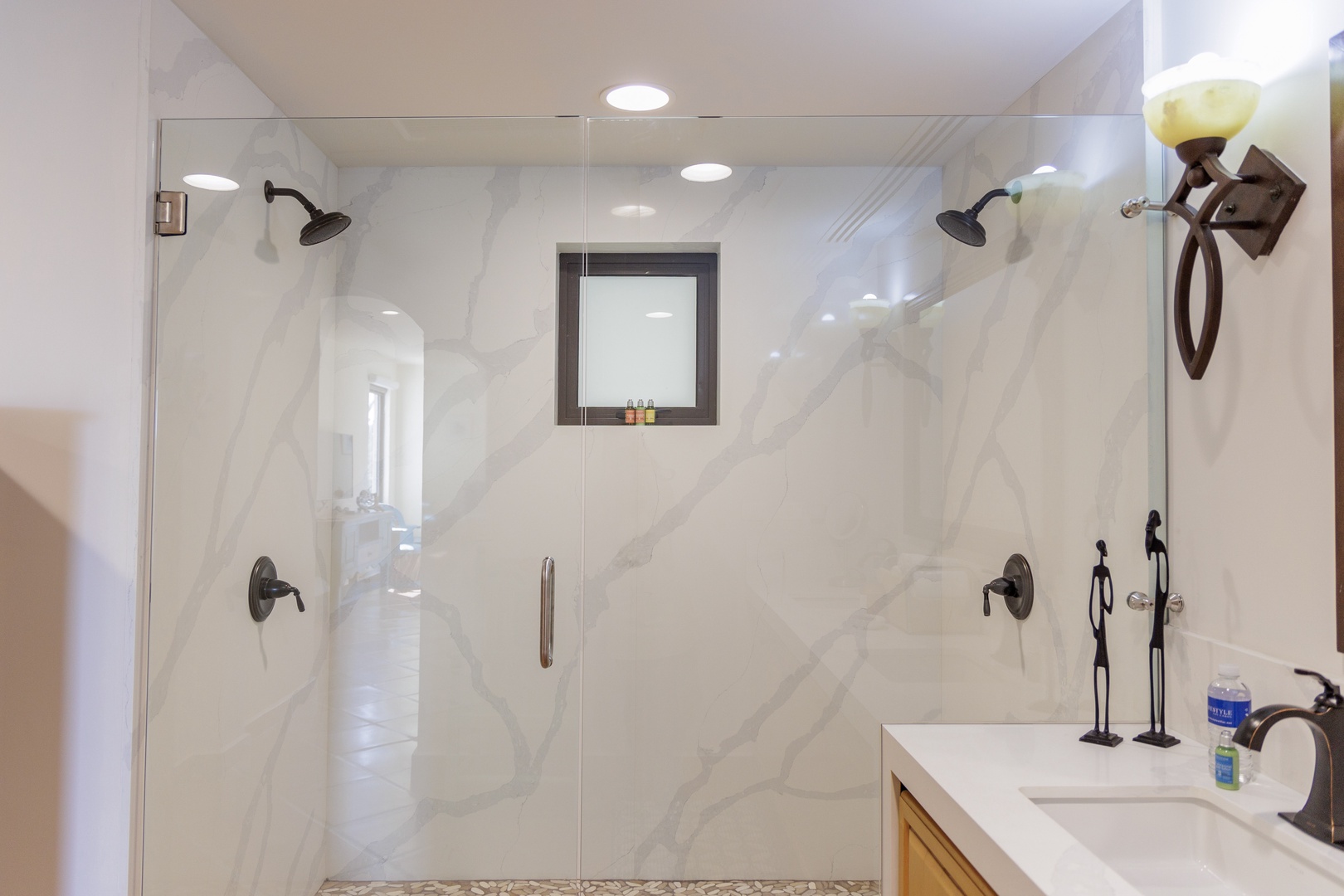 Step into your luxurious dual-head shower with elegant marble-look walls and rainfall fixtures, offering a spa-like retreat where you can unwind after a day of adventure.