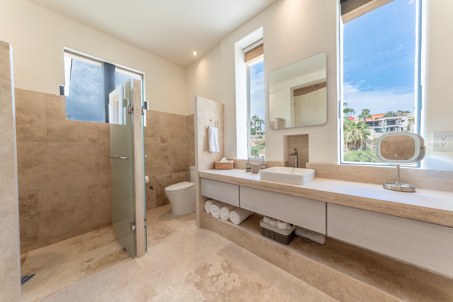 Step into your private spa-like bathroom with warm stone finishes, a sleek walk-in shower, and stunning views that transform your daily routine into pure relaxation.