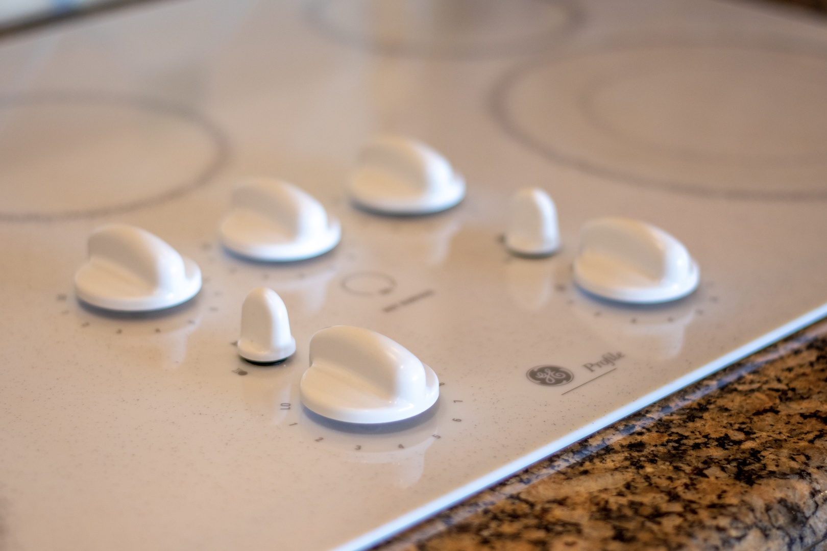Modern stovetop with sleek controls and granite countertops—your kitchen is fully equipped for preparing home-cooked meals during your stay.