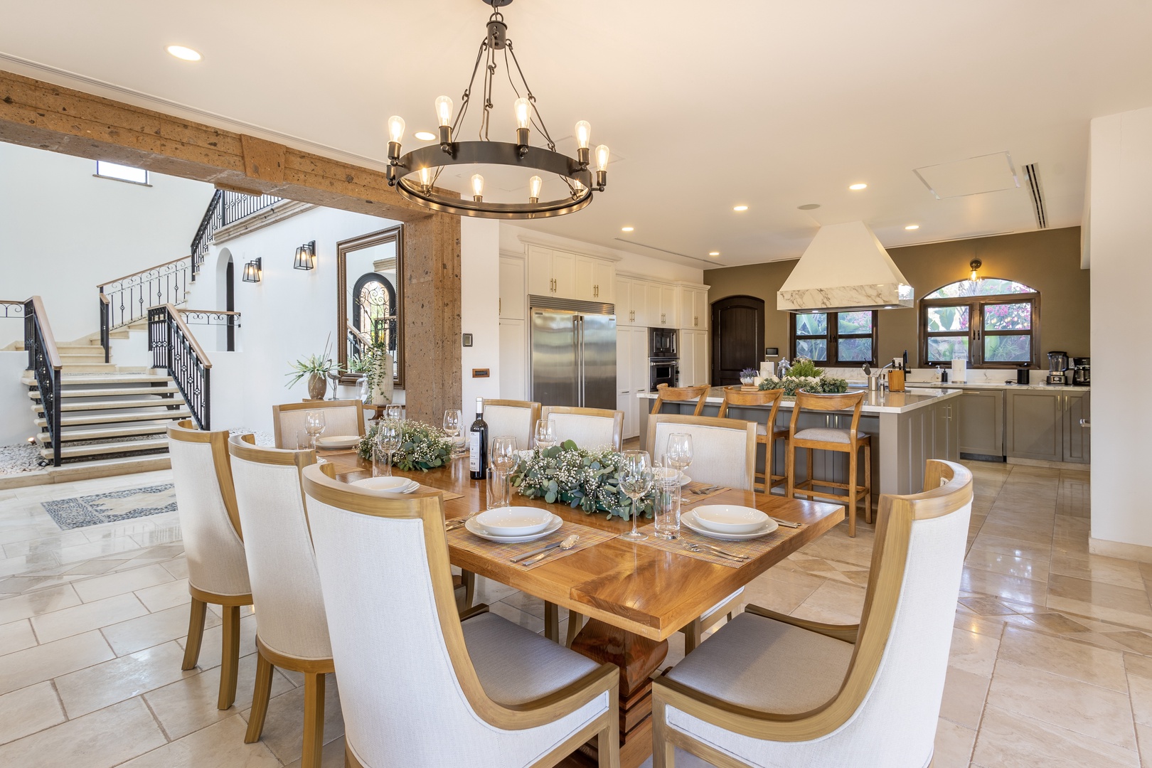 Gather around this handsome dining table with family and friends, where rustic wood beams and elegant chandeliers create the perfect ambiance for memorable meals together.