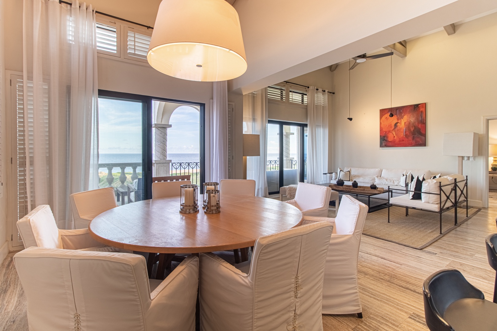 Gather around the handsome round dining table, where your group can share meals while gazing out at stunning sea views through floor-to-ceiling windows. The open living area flows seamlessly, inviting relaxation after days spent exploring.