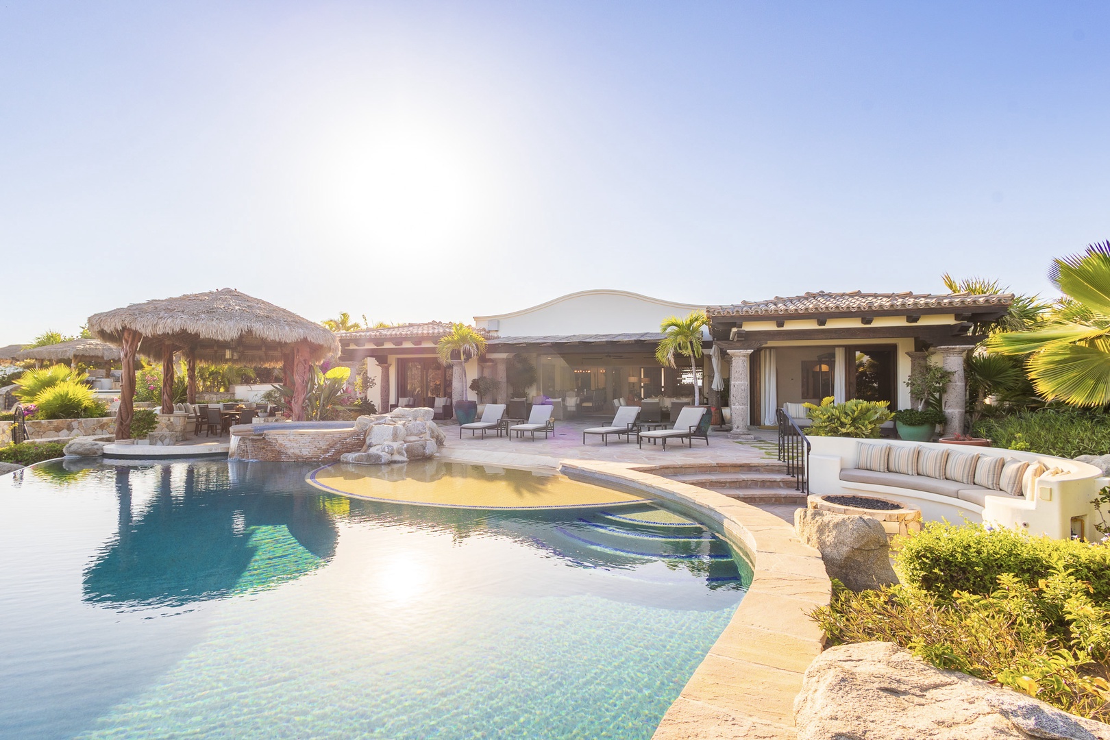 This luxurious villa features a stunning resort-style pool, spacious covered outdoor lounge, and lush tropical landscaping—perfect for relaxing in the warm sunshine and enjoying seamless indoor-outdoor living.