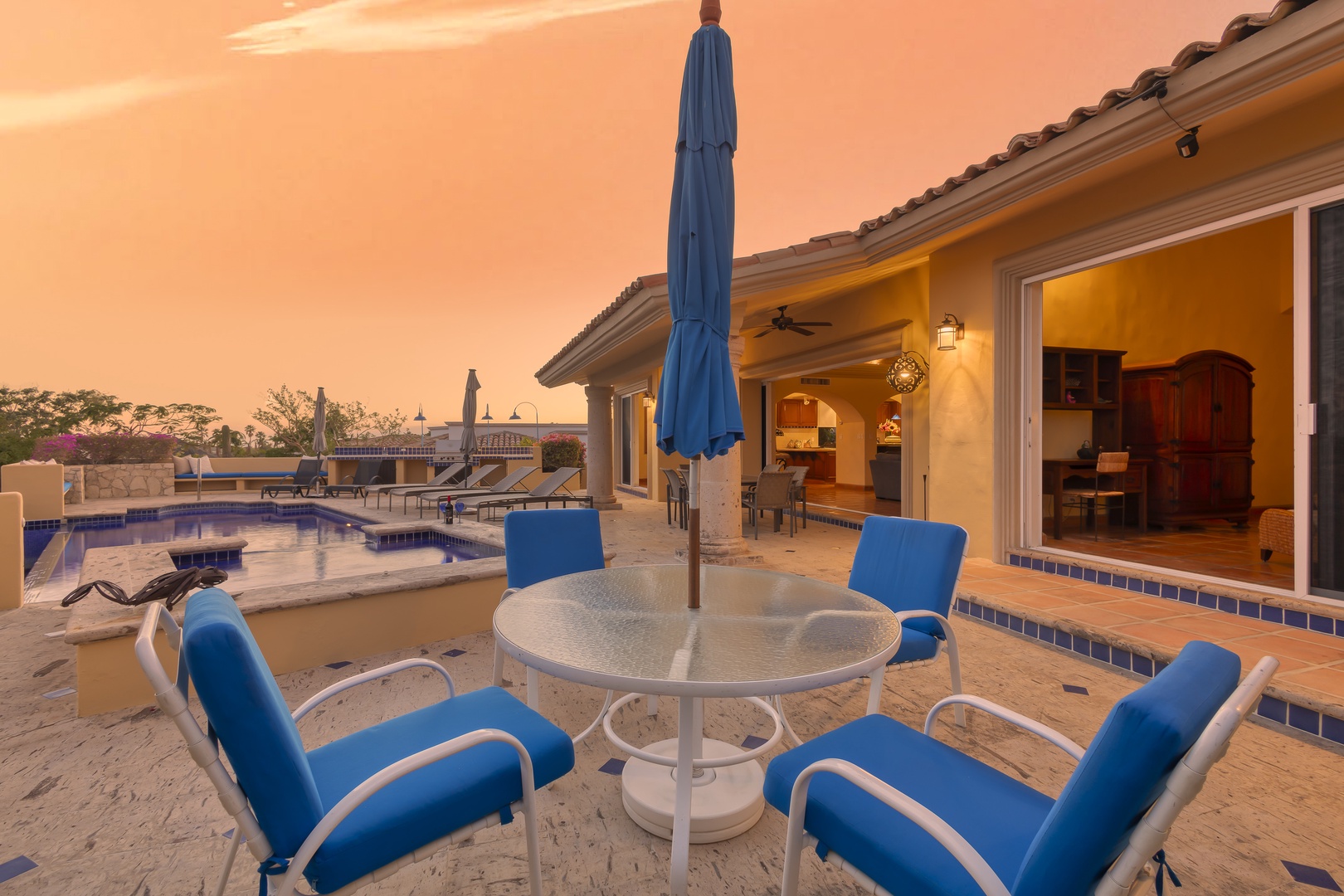 Stunning sunset views paint the sky as you relax by your private pool on this spacious patio with comfortable dining seating.