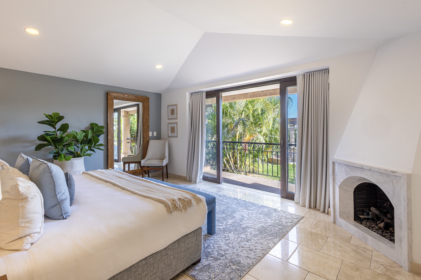 Wake up to lush tropical views from your private balcony, where palm trees sway beyond elegant glass doors. Sink into the plush king bed and enjoy cozy evenings by your fireplace in this serene, light-filled retreat.