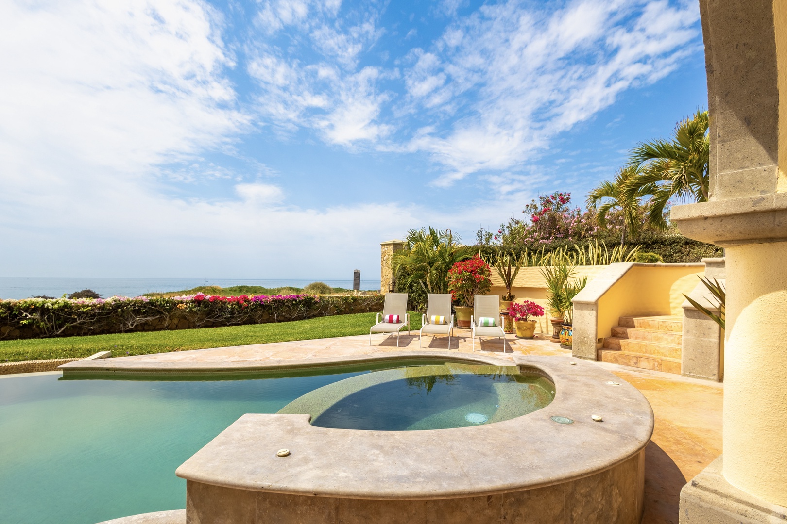 A secluded pool awaits, framed by vibrant tropical gardens and sweeping ocean views. Sink into a lounge chair and feel the coastal breeze as you gaze at the horizon.