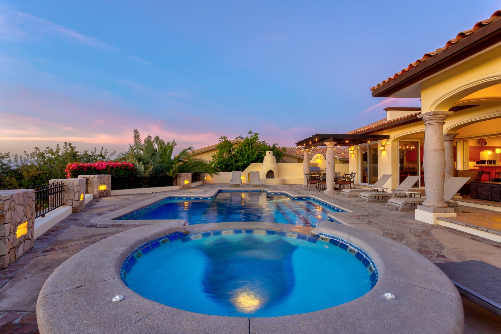 Luxurious villa pool and spa at sunset showcase elegant outdoor entertainment spaces with stunning twilight ambiance.