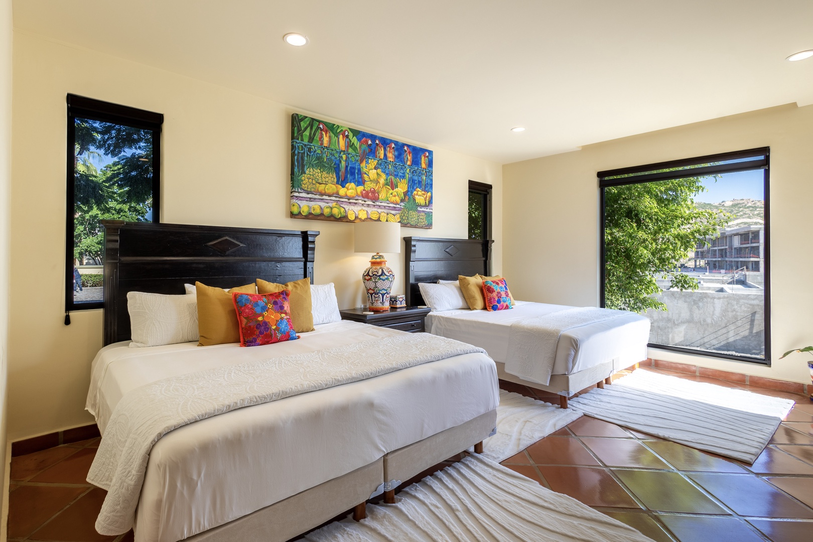Rest peacefully in your bright twin bedroom with colorful art and garden views streaming through large windows.