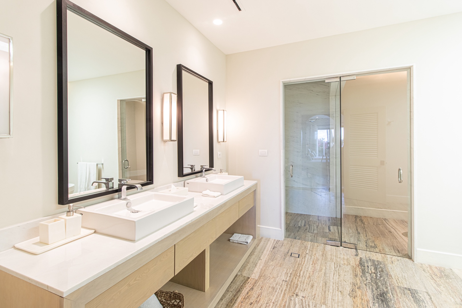 Your spa-like bathroom awaits with dual vessel sinks, sleek modern fixtures, and a spacious glass-enclosed shower—perfect for unwinding after a day exploring the area.