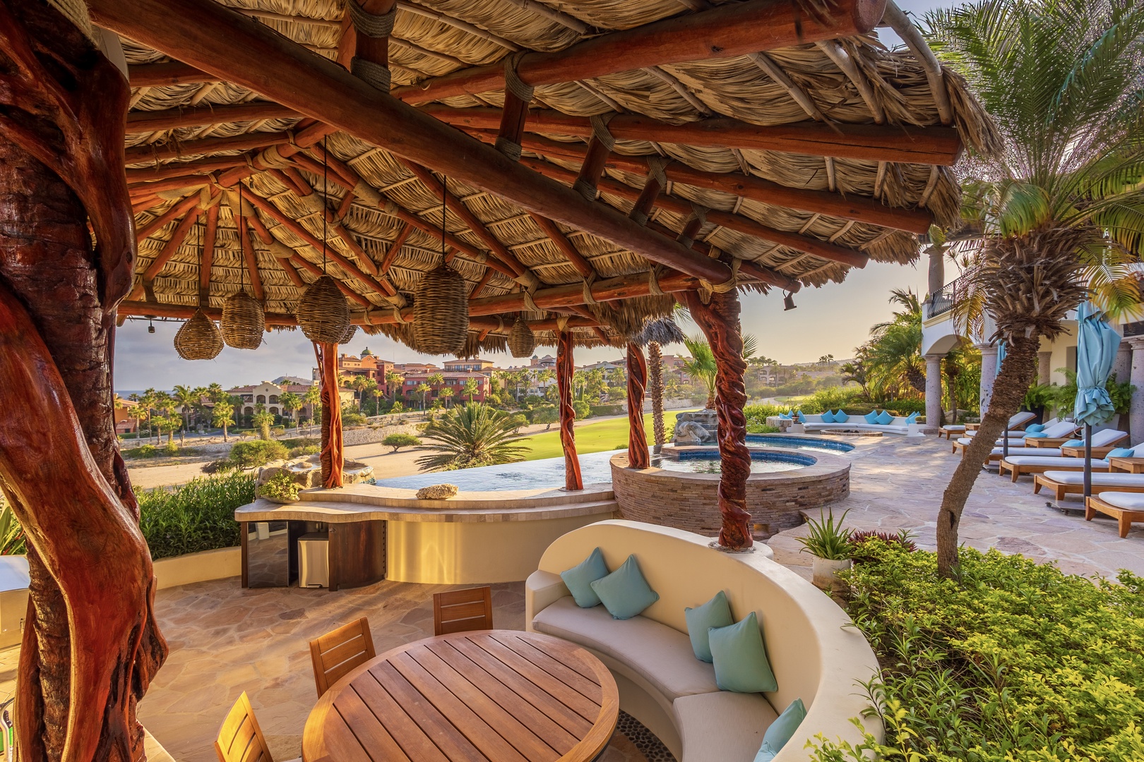 Sink into curved seating under your private palapa, where rustic-chic design meets poolside luxury. Cool afternoon breezes, garden views, and the shimmer of water create your own tranquil oasis.