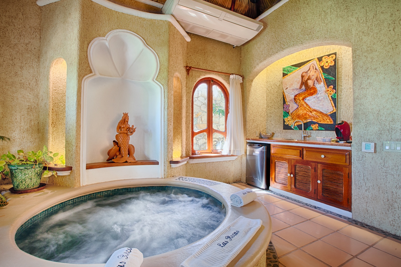 Unwind in your private hot tub sanctuary, where artistic touches and warm lighting create the perfect atmosphere for relaxation.