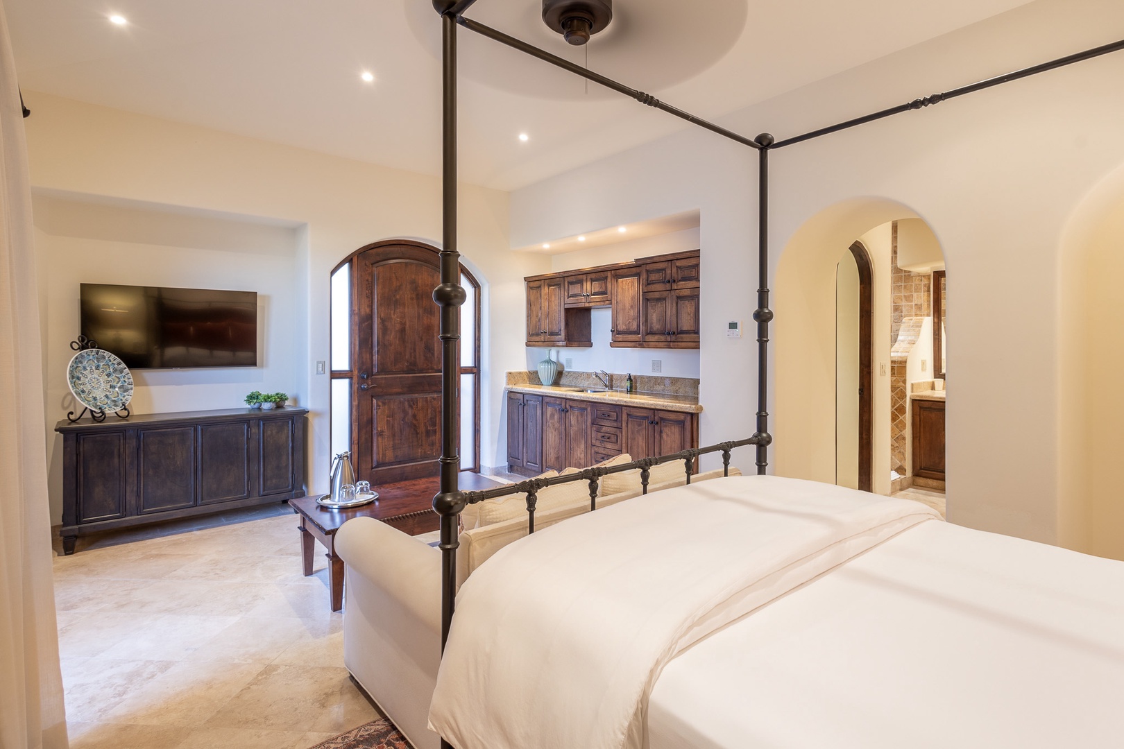 Sink into the plush four-poster bed and enjoy your private suite with rich wood furnishings, entertainment center, and en-suite bath through the elegant archway.