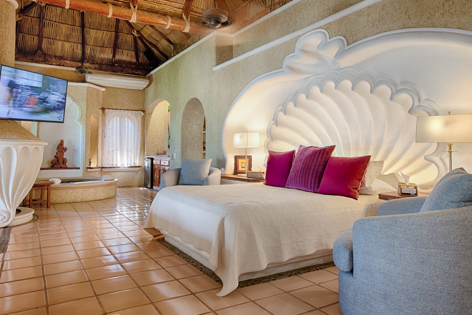 Drift into dreams beneath your stunning shell-shaped headboard, where vibrant pillows invite rest in this uniquely designed suite.
