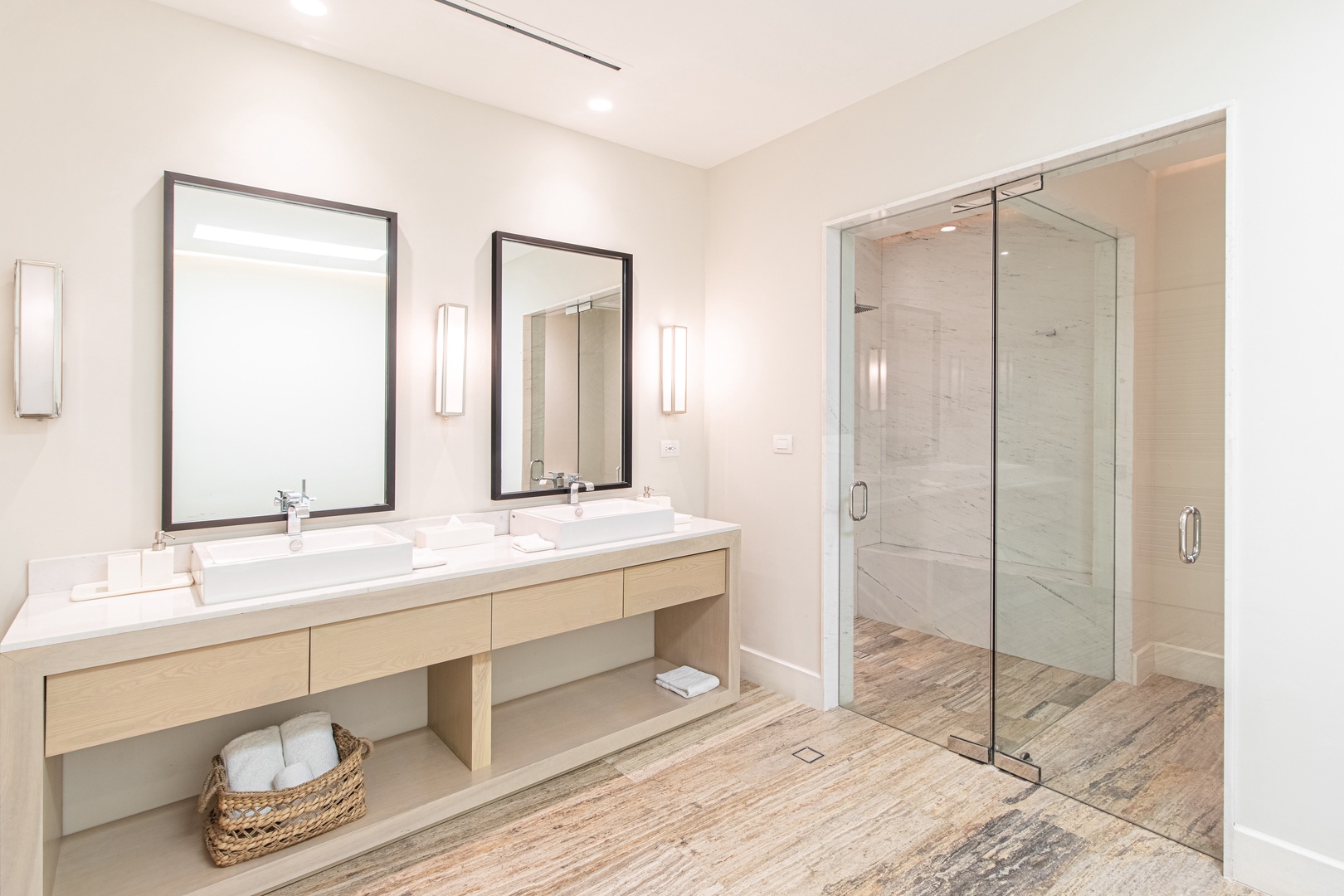 Step into your serene spa-like bathroom with dual vanities and an expansive walk-in shower. Crisp white finishes and warm wood tones create the perfect space to refresh and recharge during your stay.