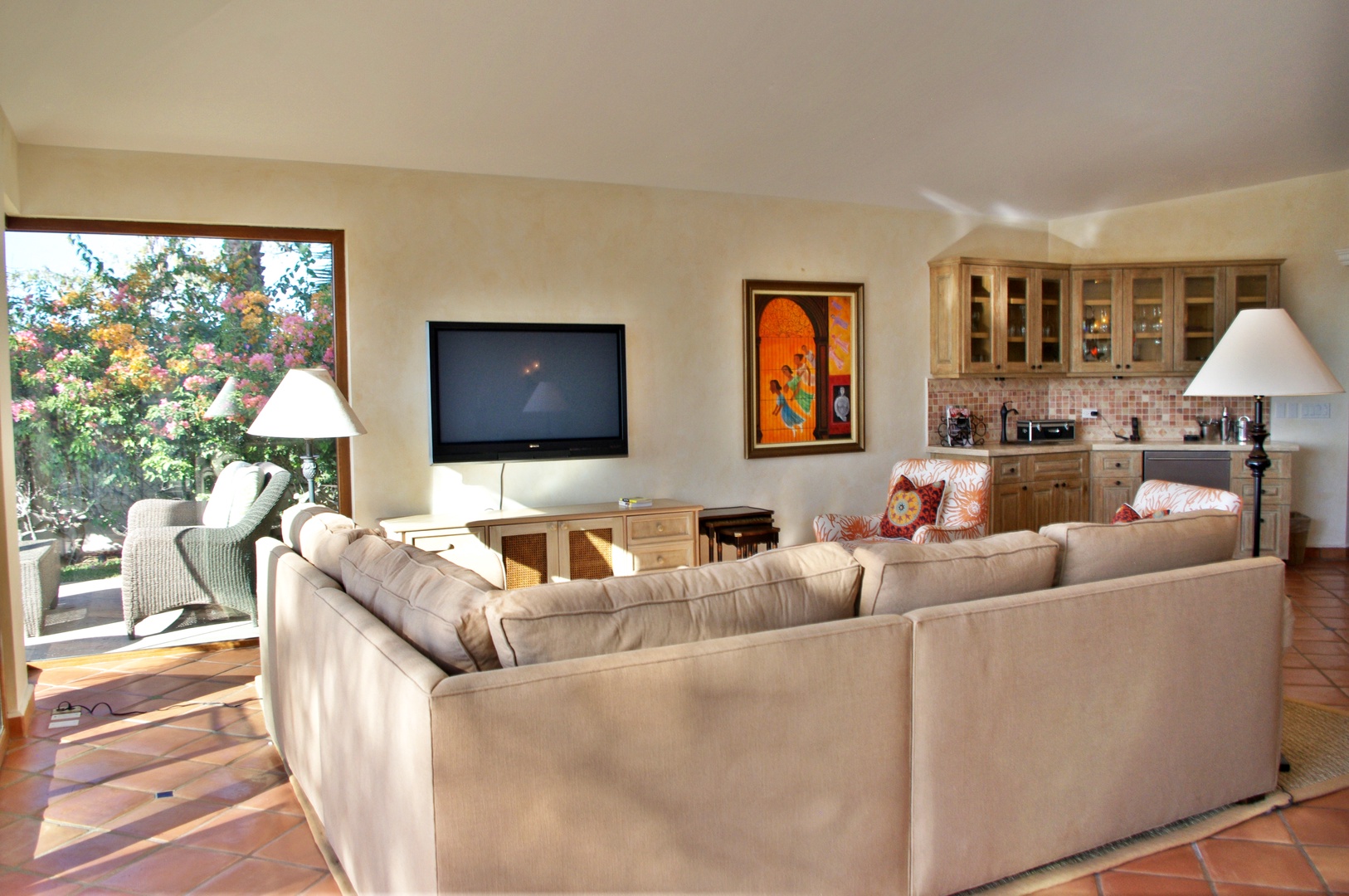 Relax in this sun-drenched living space where plush seating invites you to unwind with garden views, and a fully-equipped kitchenette stands ready for your convenience.