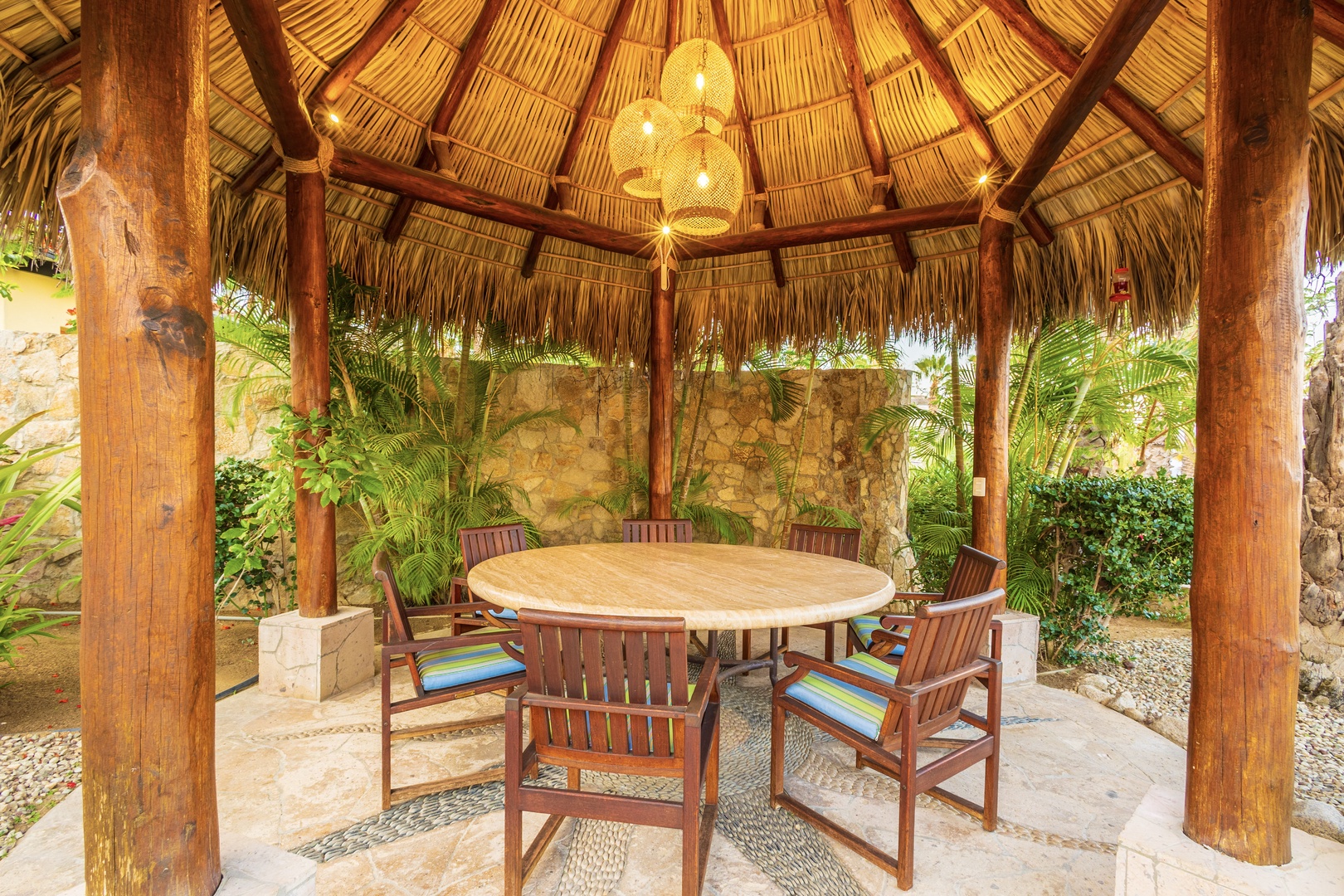 Gather under your private palapa for meals surrounded by lush tropical greenery and the rustic charm of natural stone and wood. This serene outdoor space invites relaxed dining and conversation.