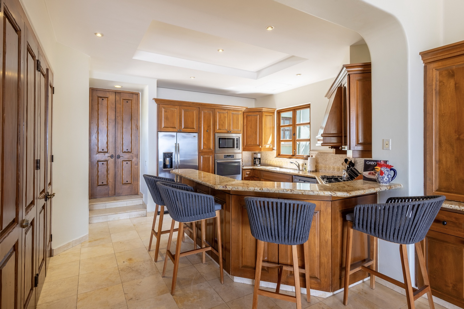 Gather around this stunning kitchen island with gorgeous granite countertops and rich wood cabinetry, perfect for your morning coffee or evening conversations.
