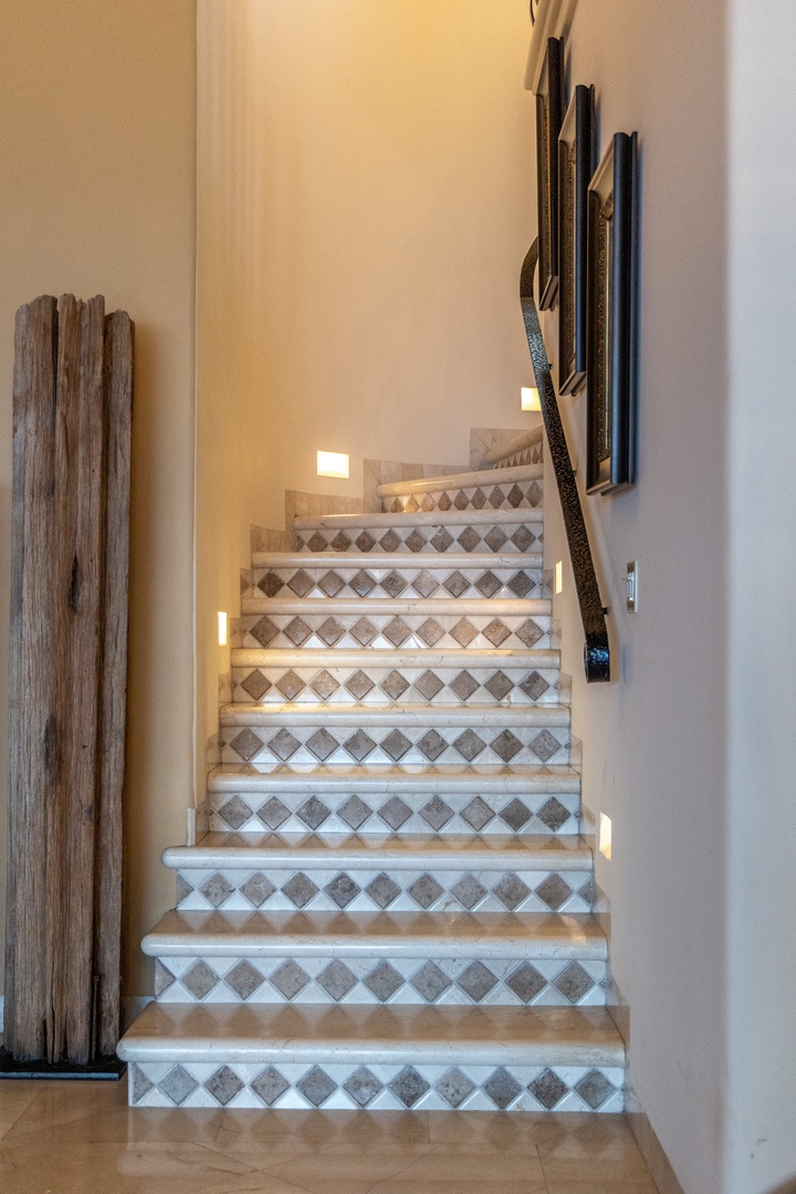 Climb beautifully tiled stairs adorned with decorative patterns and soft ambient lighting, creating a warm and inviting path as you move between floors of your retreat.