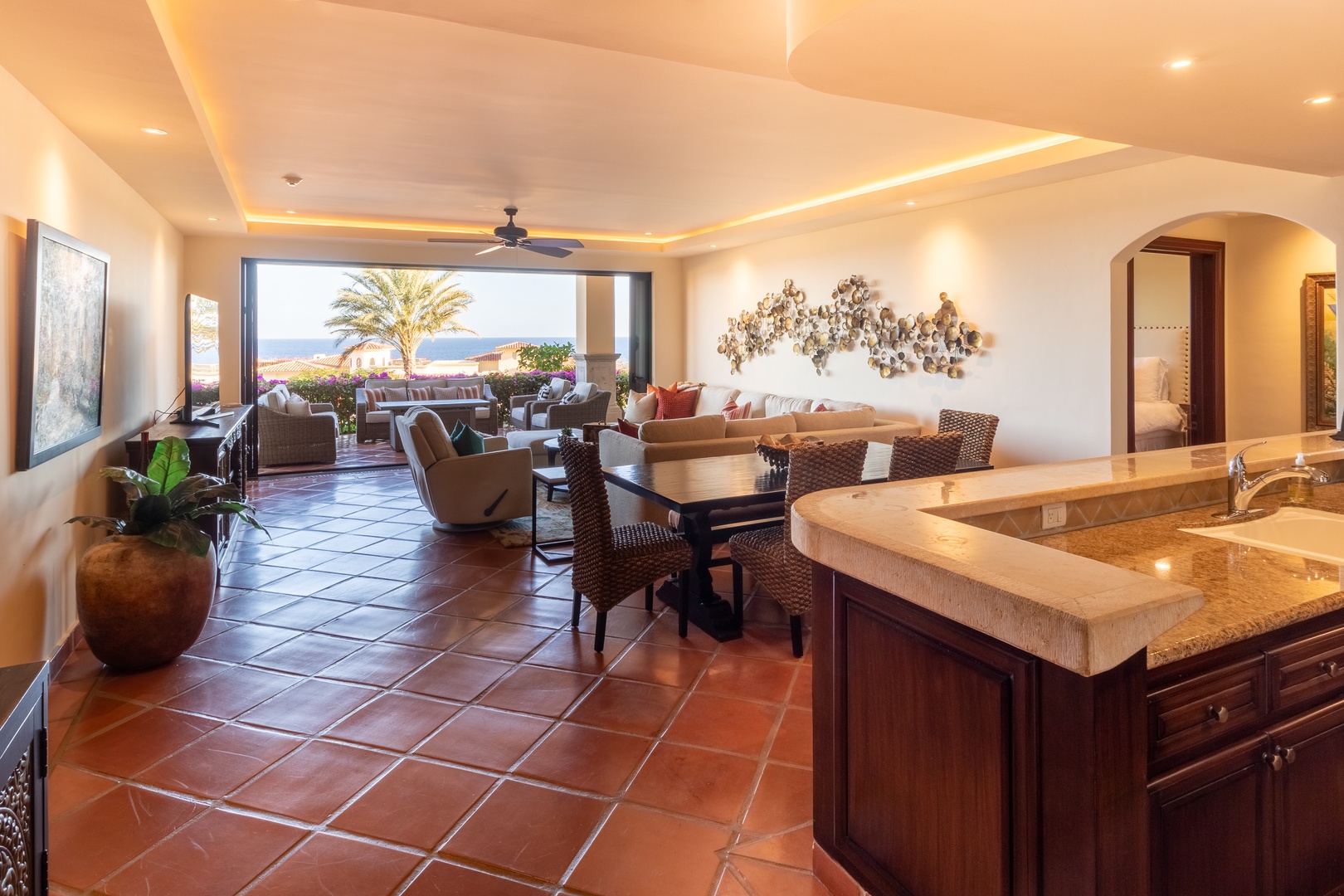 Spacious open living with terracotta floors and ocean views. Your fully equipped kitchen flows into a comfortable lounge and dining space, all bathed in natural light.