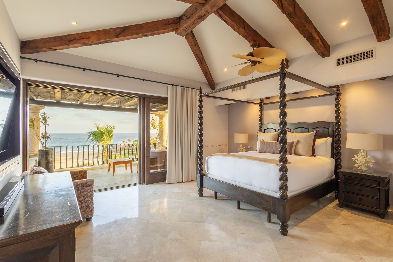 Your luxurious bedroom opens to a private terrace where ocean breezes and stunning sea views become part of your daily retreat. Drift off under vaulted wood beams with the sound of waves nearby.