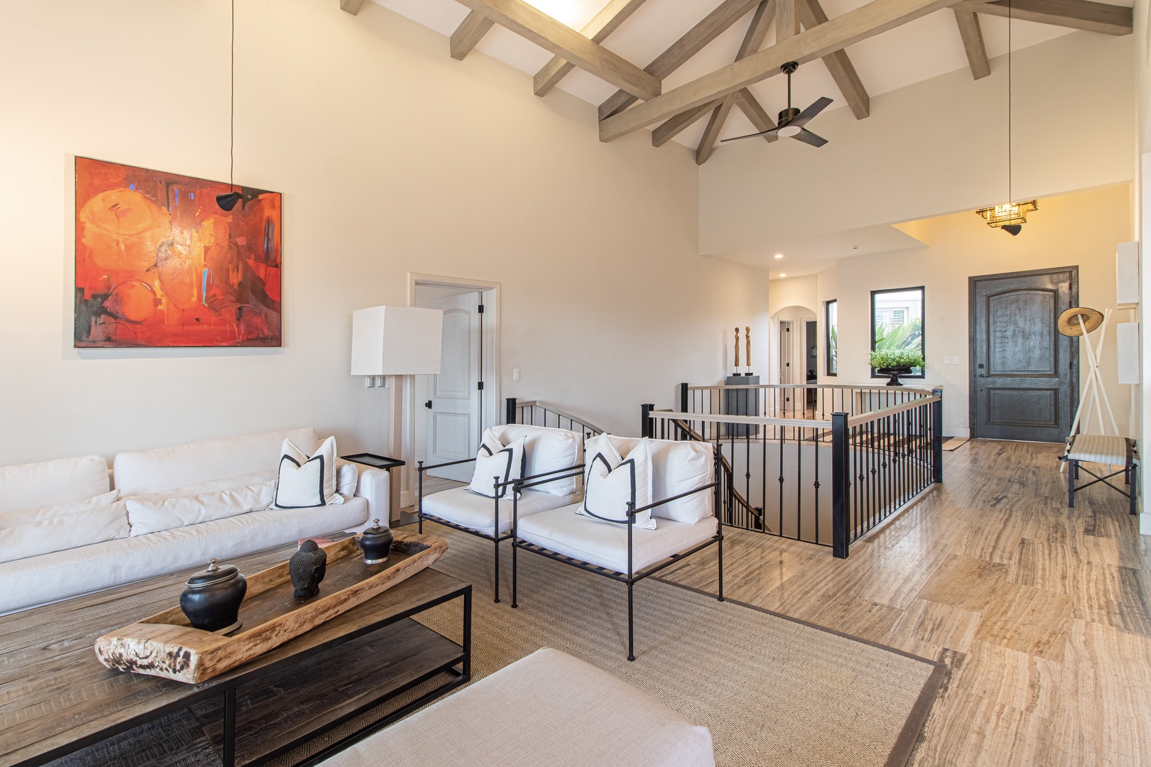 Sunlight filters through soaring beamed ceilings as you settle into this airy living space. Curated artwork and plush seating invite you to relax and feel at home.