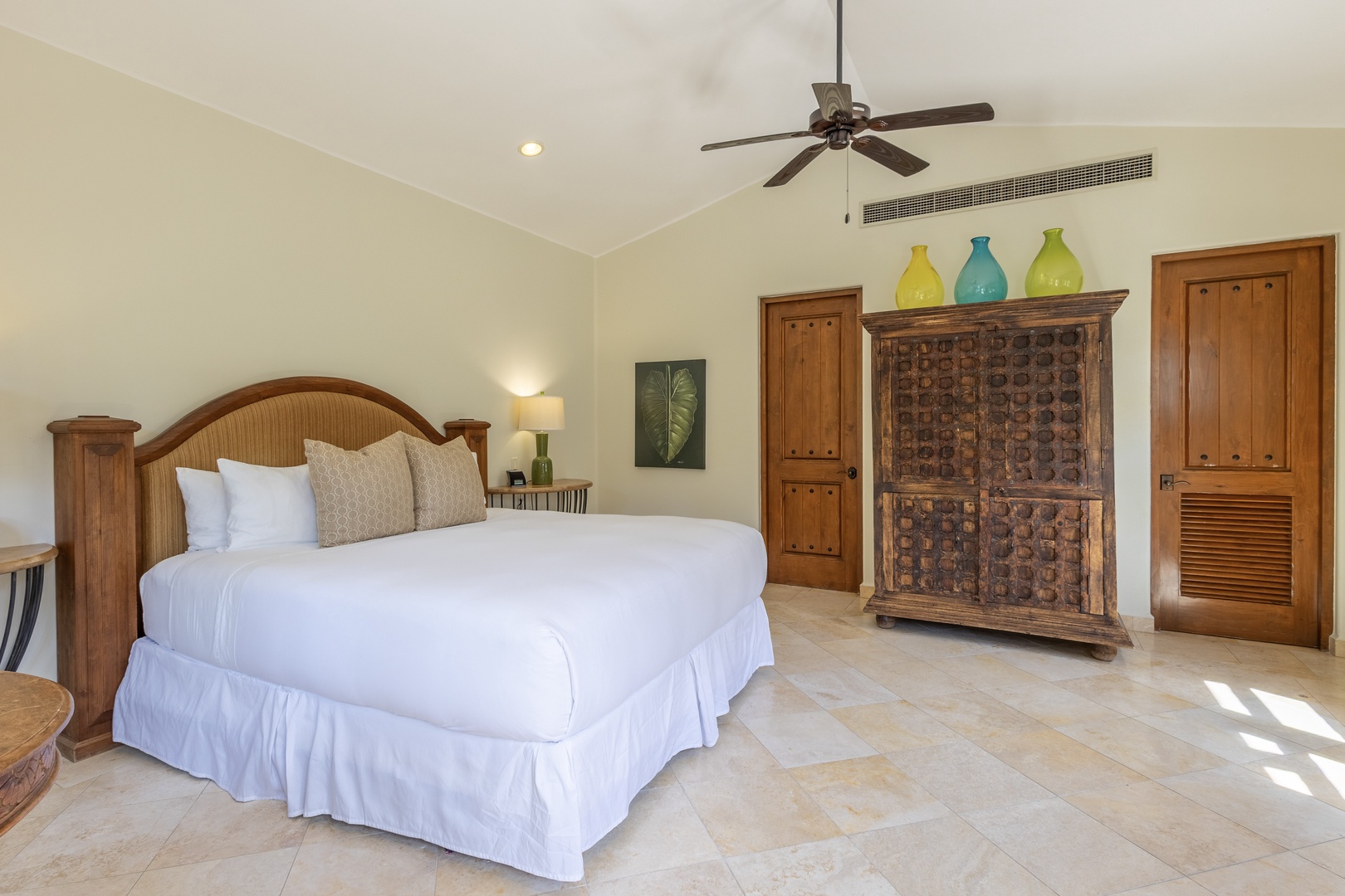 Unwind in your spacious bedroom featuring crisp linens, handcrafted furniture, and tropical touches that create a serene retreat.