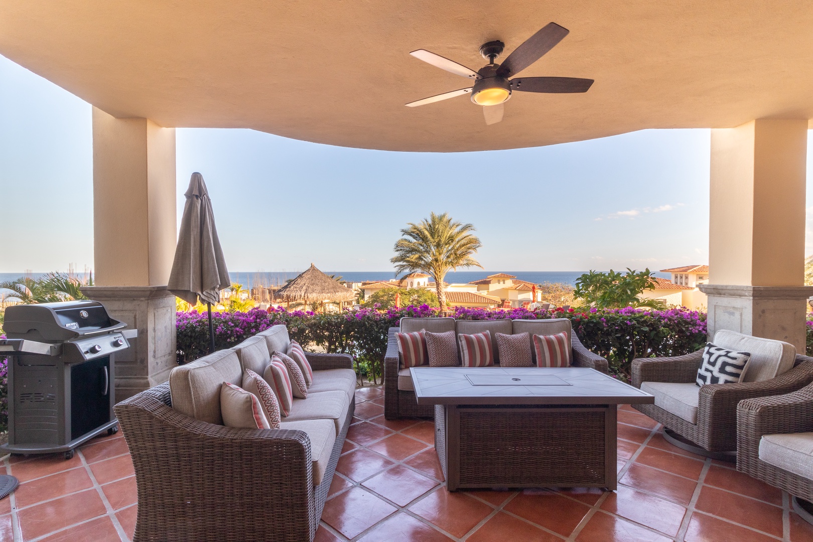 Your private terrace overlooks lush blooms and ocean views, with comfortable seating and a BBQ for al fresco dining under warm breezes.