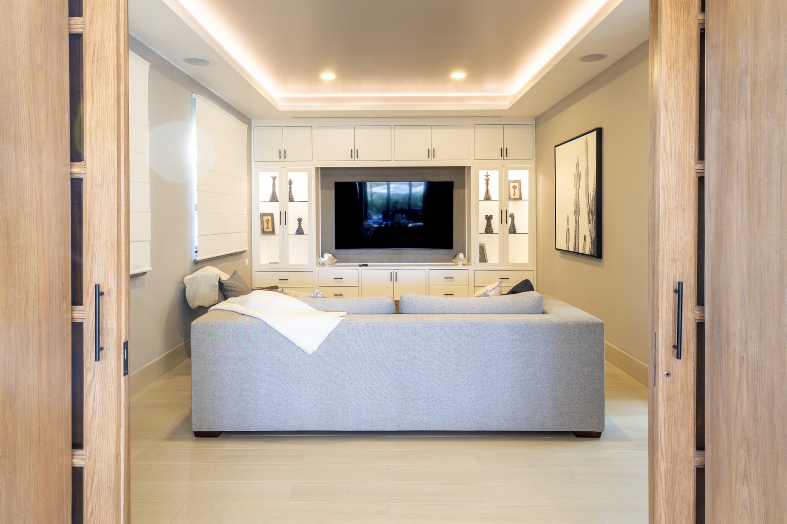 Sink into your private lounge with a plush sofa, ambient ceiling lighting, and a large flat-screen TV surrounded by elegant built-in cabinetry—a perfect space for relaxing after exploring.