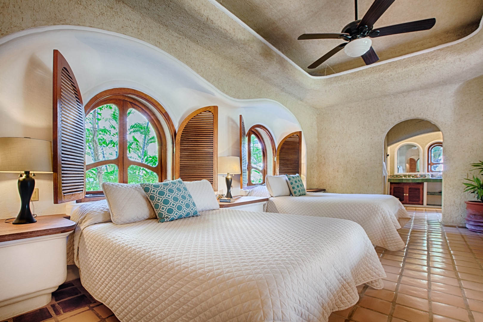 Unwind in your tropical suite with graceful arches framing lush garden views and twin beds dressed in crisp linens.