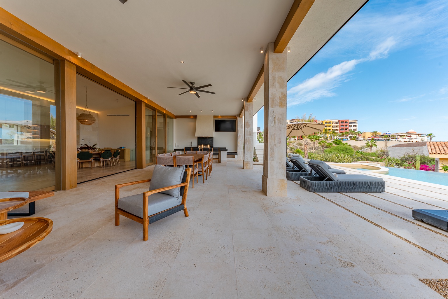 Step onto your private covered patio where modern comfort meets seamless indoor-outdoor living. Lounge by your pool while taking in serene neighborhood views and blue skies overhead.