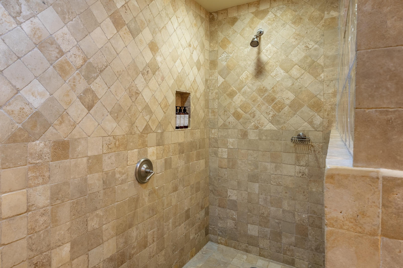 Rinse away the day in your spacious walk-in shower, featuring elegant travertine tile and a refreshing rainfall showerhead for ultimate relaxation.