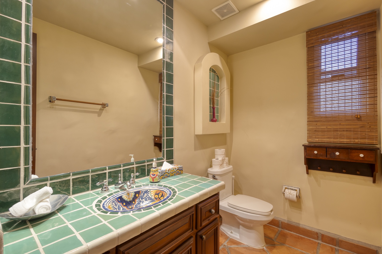 Step into your charming bathroom featuring handcrafted Mexican tiles and rustic wood vanity, creating a warm, authentic atmosphere for your daily routine.